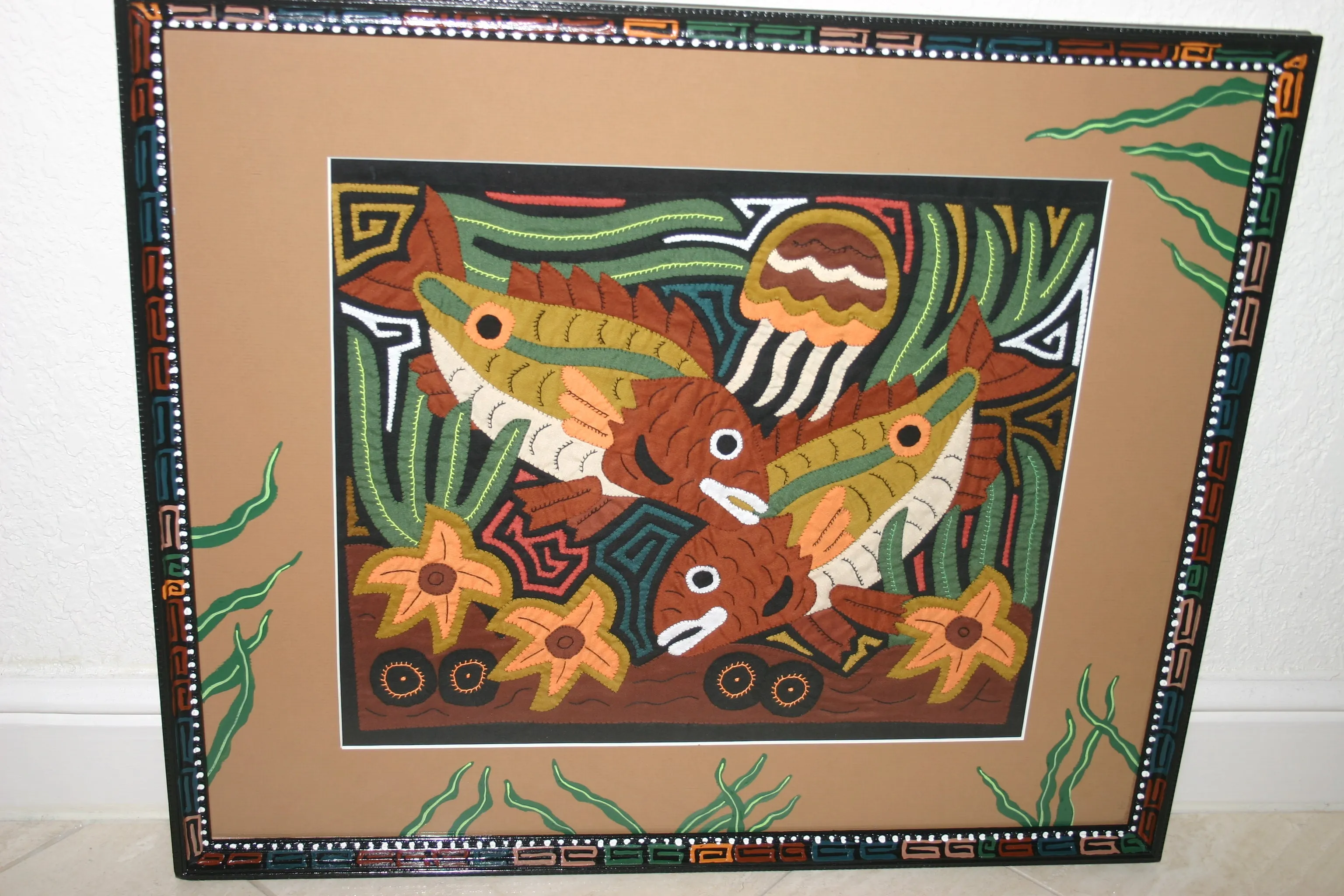 A Framed Kuna Indian Folk Art Mola from San Blas Islands, Panama in Hand Painted Frame With Wood Leaves, Glass & Double Mats. Hand stitched  Applique: Green Parrots On a Perch 20.5" X 17.5" (DFM20) WALL DECOR