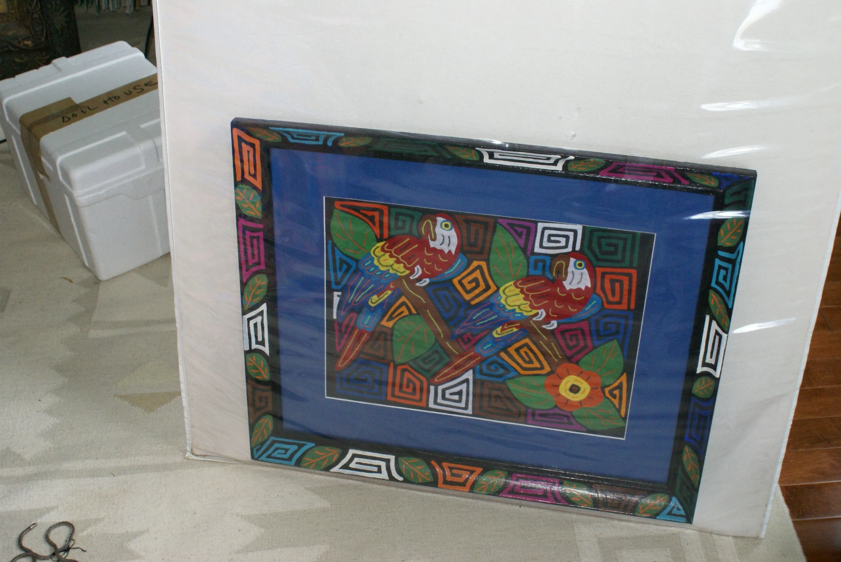 A Kuna Indian Folk Art Mola from San Blas Islands, in Custom Unique Hand Painted Signed Frame with  Blue Mat: Hand stitched Textile Applique: Colorful Macaw Parrot & Hibiscus Flowers, 23" x 18.5" (DFM19) Wall Decor