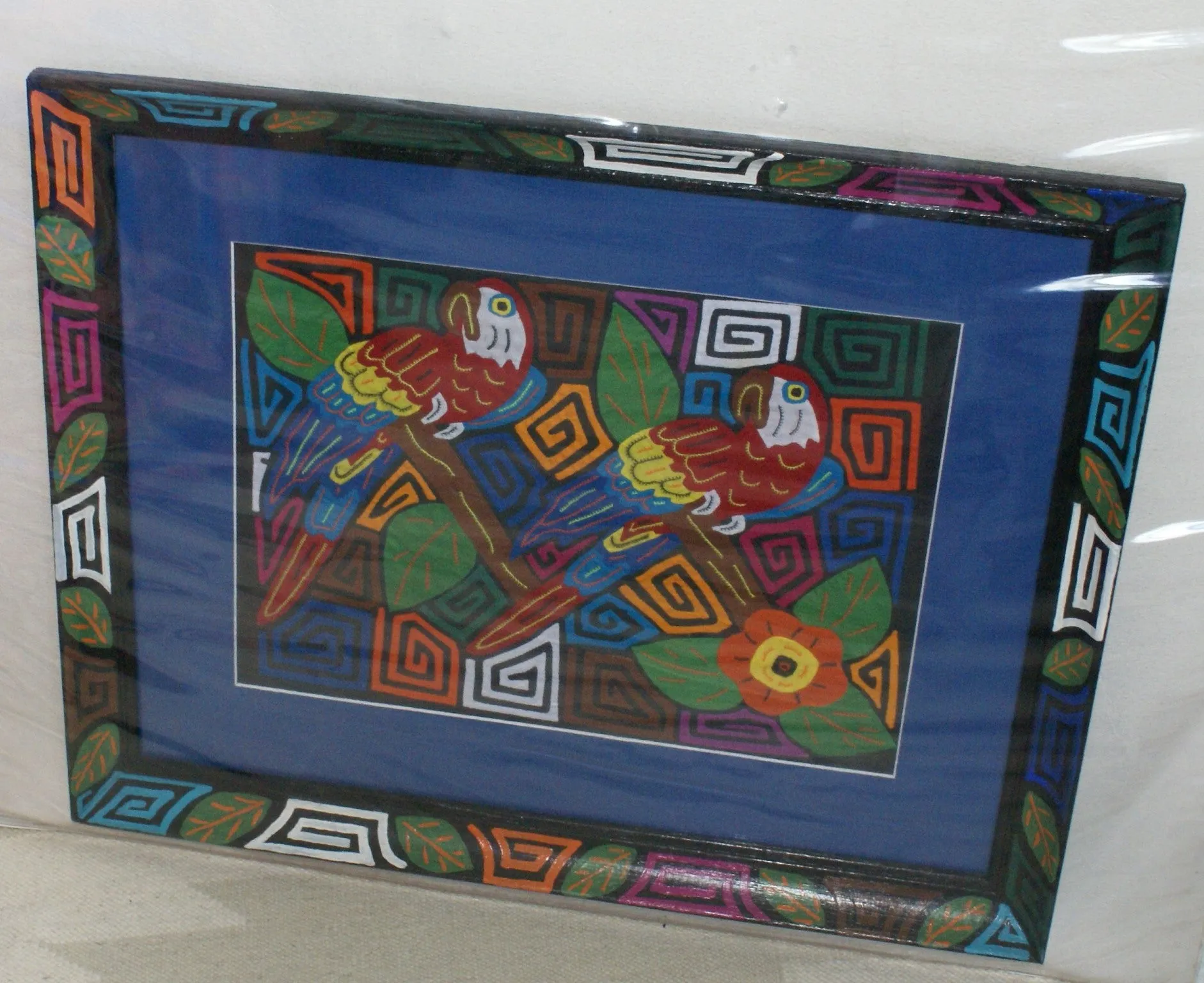 A Kuna Indian Folk Art Mola from San Blas Islands, in Custom Unique Hand Painted Signed Frame with  Blue Mat: Hand stitched Textile Applique: Colorful Macaw Parrot & Hibiscus Flowers, 23" x 18.5" (DFM19) Wall Decor