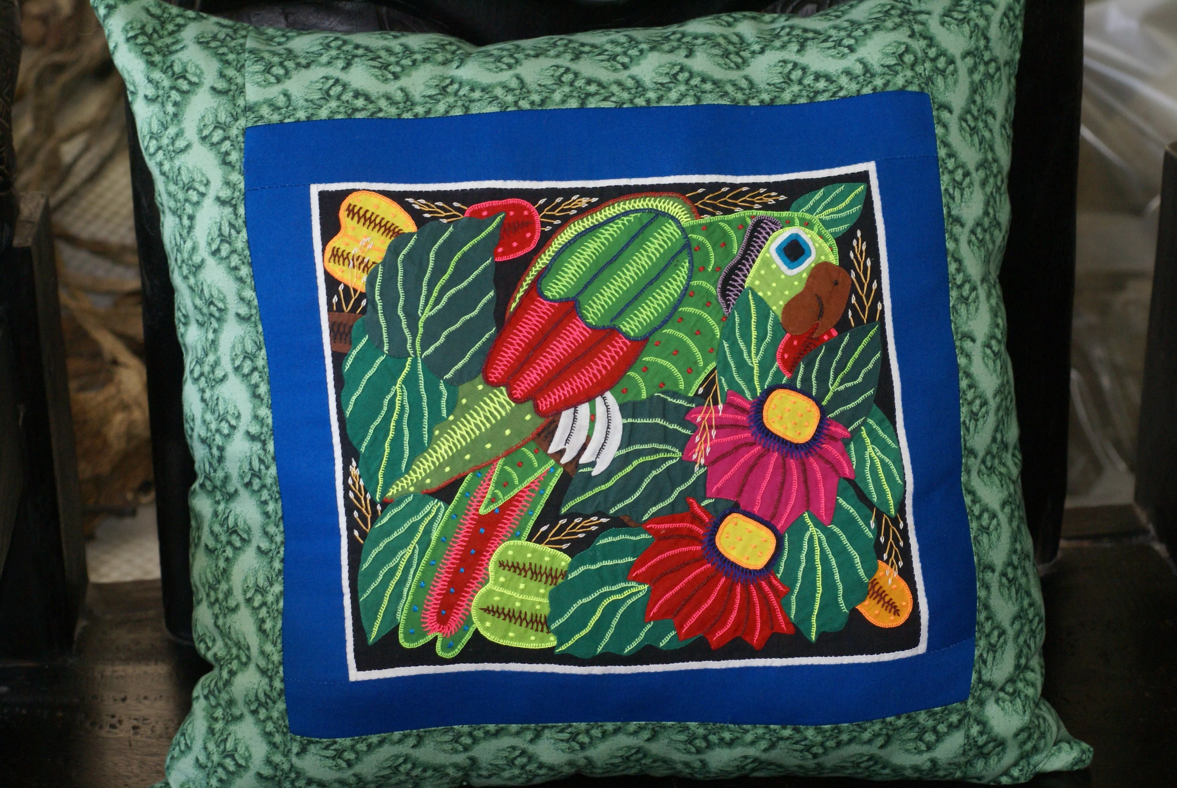 A Kuna Indian Folk Art Mola from San Blas Islands, Panama. Wall Decor, in Custom Frame & Mat. Hand stitched Textile Applique: Colorful Parrot & Hibiscus Flowers, plants 16" x 12" (DFM3)